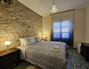 ein Schlafzimmer mit einem großen Bett und einer Steinmauer in der Unterkunft Origin Suites Urla in Urla