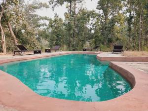 una piscina con agua verde en un patio en Emerald Tiger Retreat, en Tāla