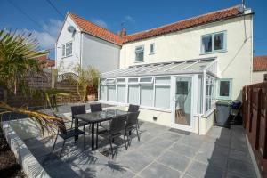 a patio with a table and chairs in front of a house at Bakers House - 4 Bedrooms - Parking for 3 cars - Dogs welcome in Wells next the Sea