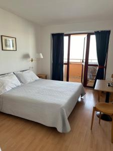 a bedroom with a bed and a large window at Nauthotel in Grado