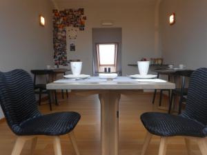 una mesa con sillas y platos encima en b&b Kraaiberg, en Heuvelland