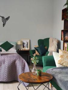 een woonkamer met een groene bank en een tafel bij Apartament w Złotym Stoku Przystanek Las in Złoty Stok