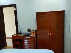 1 dormitorio con escritorio y armario de madera en Nhà Nghỉ Như Ý Ngã 6, en Pho Mới