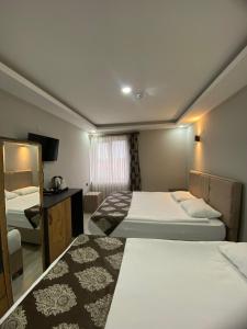 a hotel room with two beds and a television at Whitestone Hotel in Nevsehir
