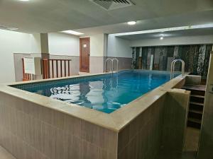 Una gran piscina con agua azul en un edificio. en Hotel Alisa, en Pavel Banya