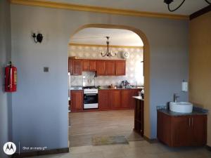 an open kitchen with wooden cabinets and a sink at Spencer Villa Sleeps 10 with Pool in Dar es Salaam +42 photos