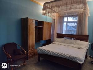 達累斯薩拉姆的住宿－Immaculate 5-Bedroom Villa Garden in Dar es Salaam，一间卧室设有一张床、一个窗口和一把椅子