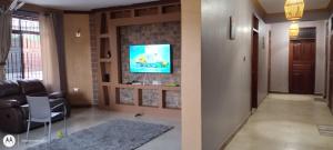 a living room with a tv on a brick wall at Immaculate 5-Bedroom Villa Garden in Dar es Salaam in Dar es Salaam