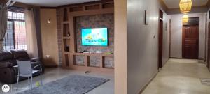 a living room with a tv on a brick wall at Spencer Villa Sleeps 10 with Pool in Dar es Salaam