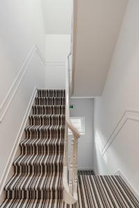 una escalera con alfombra de rayas marrón y blanco en Maison Bruges, en Brujas