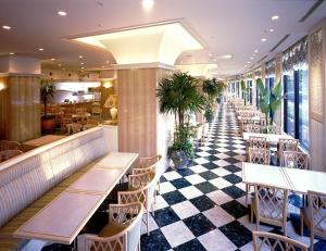 a restaurant with tables and chairs and a checkered floor at Kagoshima Sun Royal Hotel in Kagoshima