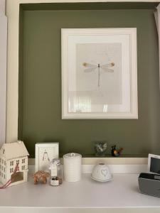 a picture of a white shelf with a picture of a clock at Casa Clima di fronte al parco in Bologna