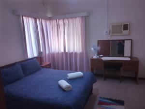 BrandvleiAccommodation Kolarita's Guesthouse, Brandvlei, NC的卧室里有一张蓝色的床，床上有两条毛巾