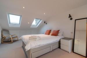 a white bedroom with a bed with towels on it at Luxury 3 Bed House in Central Wimbledon Sleeps 7 in London