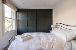 سرير أو أسرّة في غرفة في Luxury 3 Bed House in Central Wimbledon Sleeps 7