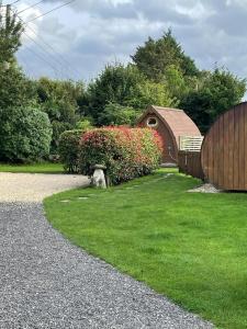 a house with a fence and a yard with grass at Beautiful Twin Glamping Pod in Salisbury in Salisbury