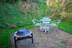 a table and chairs and a grill in a yard at Beautiful Twin Glamping Pod in Salisbury in Salisbury