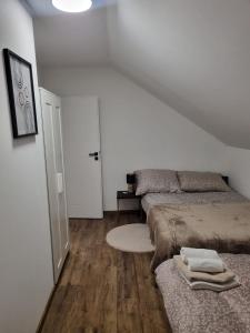 een witte kamer met 2 bedden en een tapijt bij Pustelnika Chatka nad Brennicą in Brenna