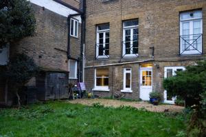 Casa de ladrillo con puerta blanca y ventanas en Manor Court en Londres