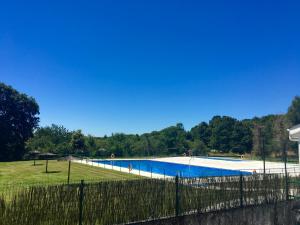 een groot zwembad in een veld met een hek bij Camino a Santiago habitaciones in Villasante