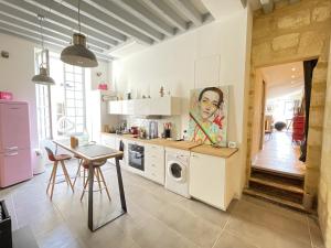 a kitchen with a washing machine and a table at Perle rare au coeur de Bordeaux - Bordeauxlidays in Bordeaux