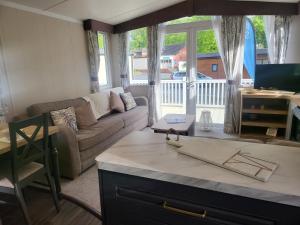 a living room with a couch and a table at Remarkable 3-Bed lodge in St Minver in Saint Minver