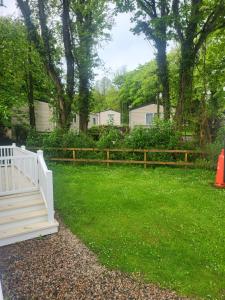 a white fence in a yard with green grass at Remarkable 3-Bed lodge in St Minver in Saint Minver