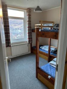 West Highland Lodge في كينلوشليفن: غرفة بسريرين بطابقين ونافذة