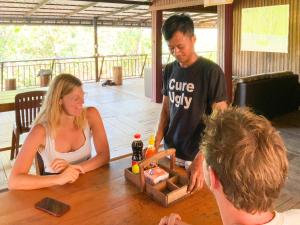 a group of people sitting around a table at Backpacker Hostel and Jungle Trekking in Banlung