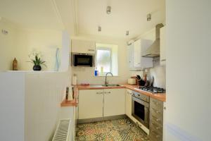 een keuken met witte kasten en een wastafel bij 4 St Michaels House in Lyme Regis