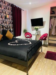 a bedroom with a bed and two red chairs at Relax Room proche PARIS Porte de Versailles in Malakoff