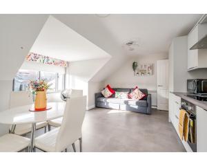 a kitchen and living room with a table and a couch at Central Belfast Apartments Utility Street in Belfast