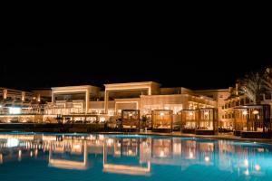 un edificio con piscina di notte di The V Luxury Resort Sahl Hasheesh a Hurghada
