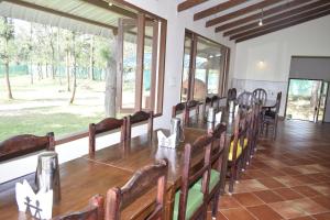 a dining room with a long table and chairs at River Valley Resort in Masinagudi