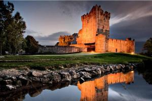a castle with its reflection in the water at Beautiful House in Killarney county kerry in Coolcorcoran Bridge