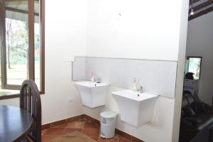 a bathroom with two sinks and a table at River Valley Resort in Masinagudi
