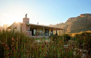 a small house with a mountain in the background at Alpha Excelsior Guest Farm in Cederberg