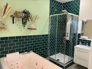 La salle de bains est pourvue d'une baignoire et d'un lavabo. dans l'établissement Dijon Studio *Balnéo du Condorcet*, à Dijon