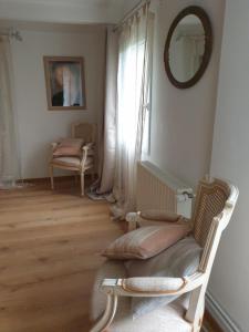 a room with a chair and a mirror and a window at La Drorie in Crouay