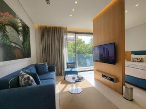 Monot Suites في بيروت: غرفة معيشة مع أريكة زرقاء وتلفزيون