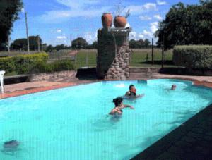 2 personas nadando en una gran piscina en Pousada Aguape en Baía