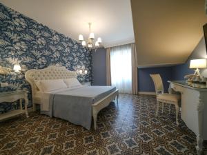 1 dormitorio con cama y pared azul en Sui Generis Tropea Luxury Rooms, en Tropea