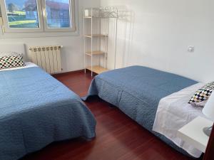 sypialnia z 2 łóżkami i półką na książki w obiekcie Apartamento en Anero w mieście Anero