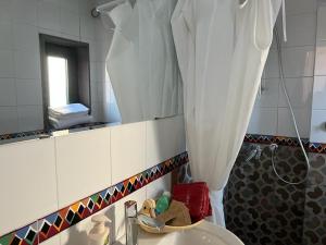 La salle de bains est pourvue d'un lavabo, d'un miroir et d'une douche. dans l'établissement Villa Venturini, à Trecase