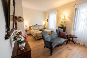 una camera con letto, sedia e vaso di fiori di Albergo Le Terme a Bagno Vignoni