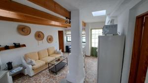 ein Wohnzimmer mit einem Sofa und einem Kühlschrank in der Unterkunft Beautiful 1-Bed House 'Oficina' Finca Vistamar in Salobre