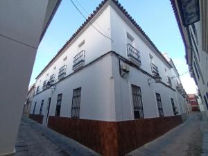 a white building with barred windows on a street at Casa San Mateo in Córdoba