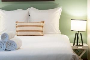 - un lit blanc avec un oreiller et une lampe dans l'établissement Escale de Giulia, à Beaune