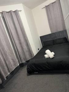 um quarto com uma cama com duas toalhas brancas em Elegant 2-Bedroom Apartment near city centre em Birmingham