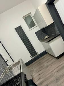 a room with a staircase with a sink and a stove at Elegant 2-Bedroom Apartment near city centre in Birmingham